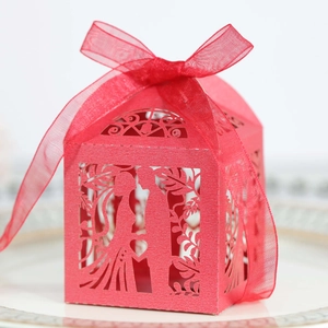 Detailed laser-cut heart pattern on a red pearlescent paper wedding gift box with ribbon