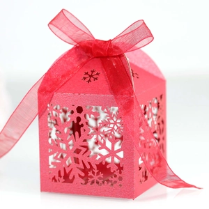 Detailed laser-cut snowflake patterns on a festive red gift box with a ribbon bow