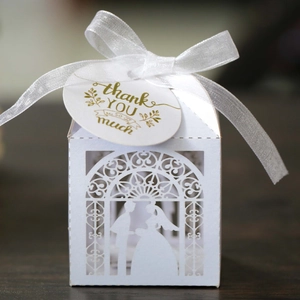 Detailed laser-cut white wedding favor box with bride and groom silhouette and bow