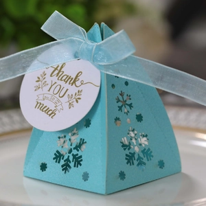 Detailweergave van piramide geschenkdoos met sneeuwvlokken en een label met een lint