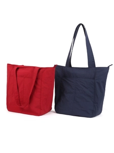 Dettaglio delle borse tote in tela rossa e blu con trama in nylon e tasche anteriori