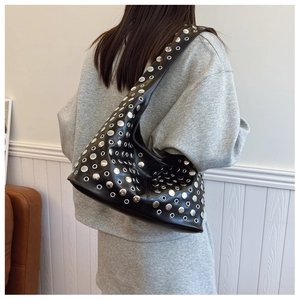 Détail du sac hobo punk en cuir noir avec œillets et rivets argentés sur le modèle