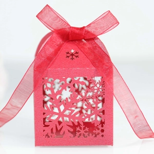 Close-up of red laser-cut snowflake candy box with elegant organza ribbon bow