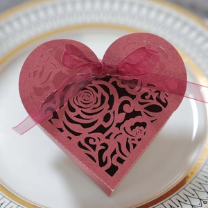 Detail of red heart gift box with laser-cut rose patterns and matching ribbon bow