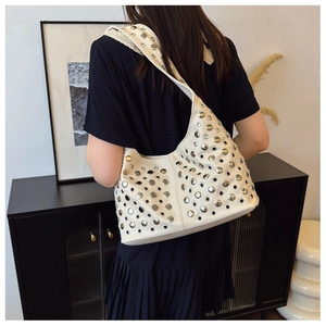 Détail du sac hobo blanc crème avec rivets et œillets métalliques argentés sur le mannequin
