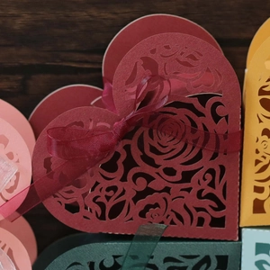 Detail of laser-cut heart candy boxes with rose patterns and matching silk ribbons