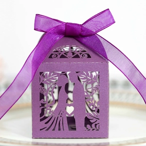 Detail of purple laser-cut wedding candy box featuring a couple silhouette and silk ribbon