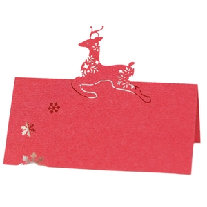 Laser cut red Christmas table card with reindeer and snowflake design for festive seating