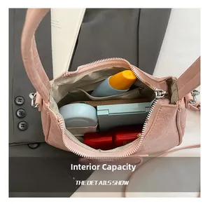 Interno borsa in pelle rosa con scomparti, tasca con zip e oggetti di uso quotidiano