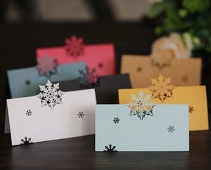 Macro shot of assorted pearl paper place cards with laser-cut snowflake designs