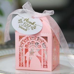Pink laser-cut wedding favor box with bride and groom silhouette and thank you tag