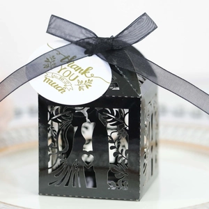 Elegant black laser-cut wedding favor box with bride and groom silhouette and ribbon