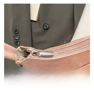 Dettagli della zip argentata e fiocco in pelle sulla borsa a pieghe rosa chic