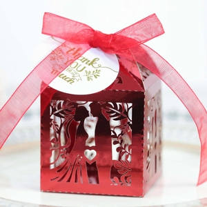 Macro view of red laser-cut wedding candy box with heart silhouette and thank you tag