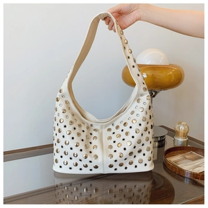 Détails du sac hobo blanc cassé avec des rivets argentés et des œillets métalliques