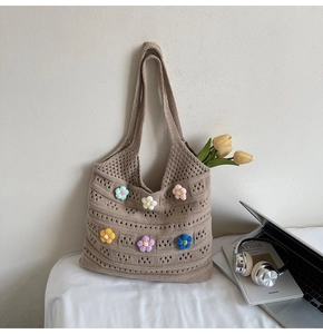 Macro shot of colorful 3D crochet flowers on a woven hollow beach tote bag detail