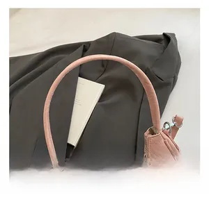 Borsa a gnocco rosa con texture in pelle plissettata e ciondolo in pizzo e perle