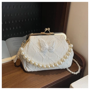 Close-up of pearl handle bag with elegant butterfly embroidery and golden clasp