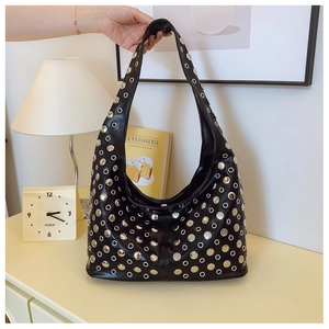 Détail d'un sac seau en cuir noir orné de rivets argentés et d'œillets métalliques