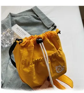 Detail of yellow nylon drawstring bag with cat embroidery and adjustable strap