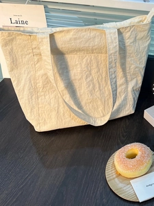 Elegante borsa tote crema con trama plissettata e tasca frontale per il tempo libero