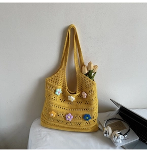 Dettaglio borsa shopper in maglia gialla con fiori all'uncinetto 3D e trama traforata