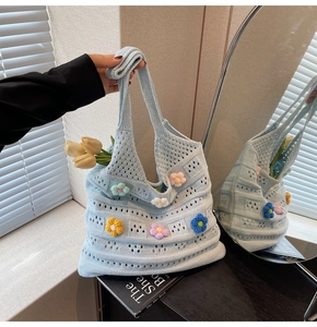 Dettaglio della borsa a maglia traforata con fiori 3D all'uncinetto e manico morbido