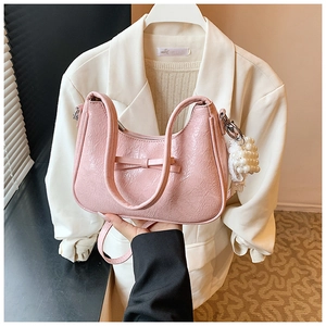 Details der rosa Plissee-Handtasche mit Schleife, Perlenanhänger und Schultergurt