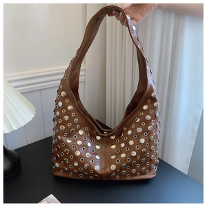 Détails macro du sac hobo marron avec rivets punk vintage et œillets métalliques argentés