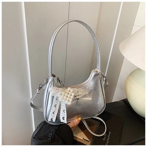Detail der silbernen Metallic-Tasche mit Spitzenschleifen und Perlenverzierungen