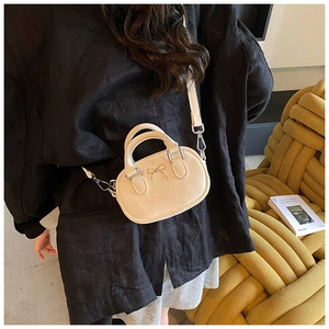 Close-up of mini off-white bowling bag with metal bow detail and fine leather texture