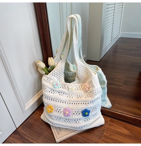 Dettaglio borsa shopper in maglia bianca con fiori 3D colorati e motivi traforati fatti a mano