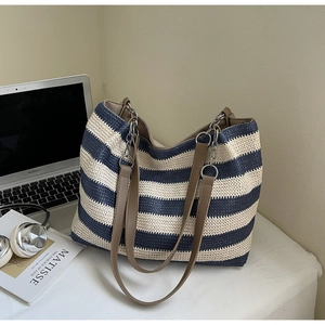 Détail du sac cabas tissé à rayures bleues et blanches avec bandoulière chaîne