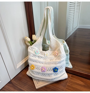 Dettaglio della borsa tote in maglia bianca con fiori 3D colorati e motivi traforati