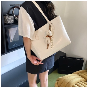 Détail du cabas blanc à motif crocodile avec un charmant petit ours en peluche