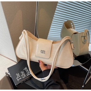 Détail de la texture en cuir verni blanc crème et boucle argentée sur le sac baguette