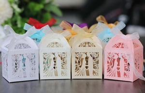 Detailed laser-cut wedding favors boxes featuring bride and groom silhouette and organza bows