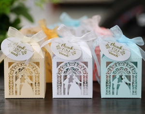 Laser-cut wedding candy boxes with bride and groom silhouettes and organza ribbons