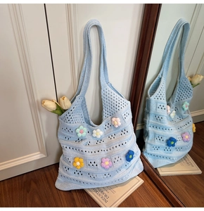 Dettaglio della borsa in maglia azzurra con fiori 3D e motivo a uncinetto traforato