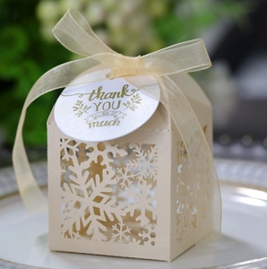 Close-up of laser-cut snowflake gift box with ribbon and thank you tag detail