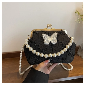 Detail of vintage black kiss-lock bag with sequin embroidery and a mesh butterfly
