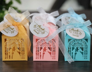 Detailed laser cut wedding candy boxes with groom and bride silhouette and silk ribbons