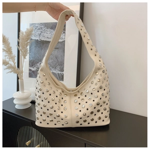 Détail du sac seau punk crème avec rivets argentés et œillets décoratifs évidés