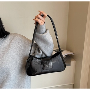 Détail du sac baguette en cuir verni noir brillant avec une boucle en métal argenté premium