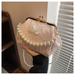 Detail of pink floral fabric kiss-lock bag with butterfly embroidery and pearl strap