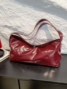 Deep red patent leather hobo bag with silver rivet straps for daily commuting
