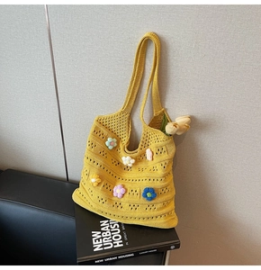 Dettaglio borsa tote in maglia gialla con fiori all'uncinetto colorati e trama traforata