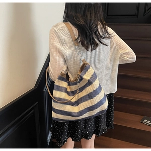 Détail du sac cabas tissé bleu et beige avec bandoulière en cuir marron et chaîne