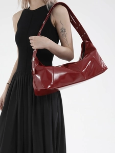 Minimalist red patent leather shoulder bag with glossy finish and silver metal buckles