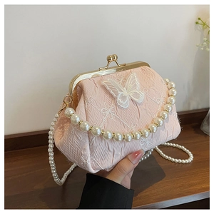 Detail of pink pleated fabric bag with white lace butterfly and golden clasp closure